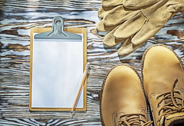 Koruyucu bot deri eldiven panosu ahşap tahta üzerinde kalem