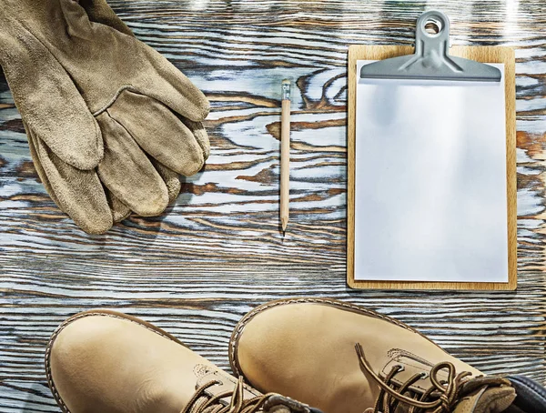 Koruyucu çizmeler eldiven panosu ahşap tahta üzerinde kalem