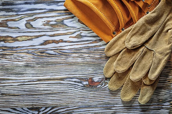Kožené ochranné rukavice budování pás na dřevěné desce — Stock fotografie