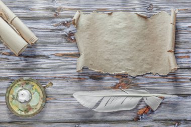 Vintage kağıt kaydırma tüy şamdan mavi ahşap zemin üzerine