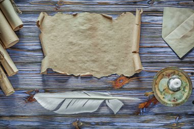 Vintage kağıt tüy şamdan mavi ahşap arka plan üzerinde yuvarlandı.