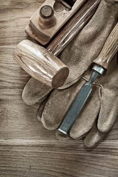 Lump hammer shaving plane chisel protective gloves on wooden boa