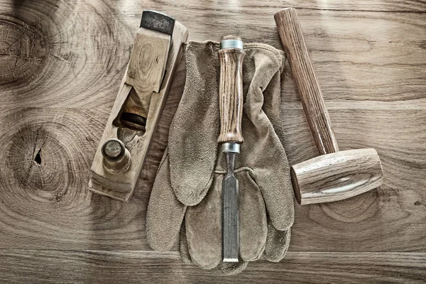 Lump hammer shaving plane chisel safety gloves on wooden board