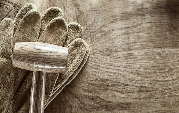 Lederen beschermende handschoenen houten hamer op een houten bord — Stockfoto