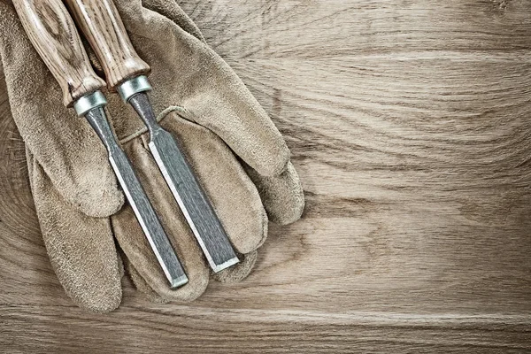 Ahşap tahta üzerinde sıkı keski deri koruyucu eldivenler — Stok fotoğraf
