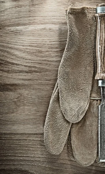 Luvas de proteção de cinzel liso na placa de madeira — Fotografia de Stock