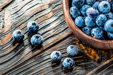 Yuvarlak ahşap kase taze yaban mersini.