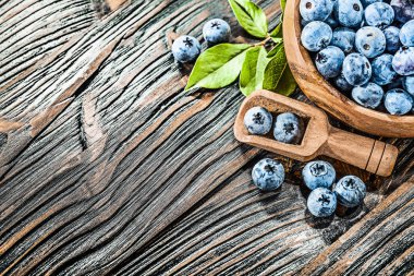 Tahta kaşık kase sulu huckleberries.