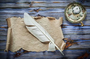 Vintage kağıt kaydırma tüy şamdan mavi ahşap zemin üzerine.