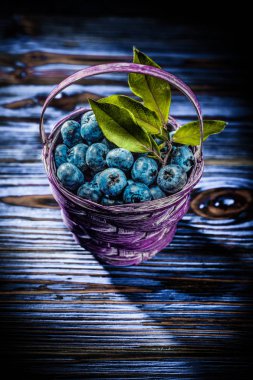 Antika ahşap tahta üzerinde sepette huckleberries.