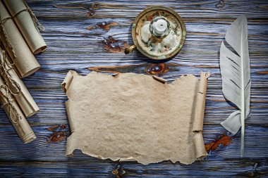 Vintage kağıt tüy şamdan mavi ahşap arka plan üzerinde yuvarlandı..