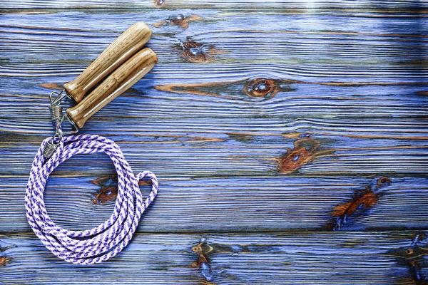 Skipping rope on blue vintage wooden board.