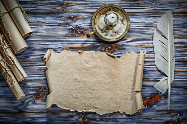 Vintage kağıt tüy şamdan mavi ahşap arka plan üzerinde yuvarlandı..