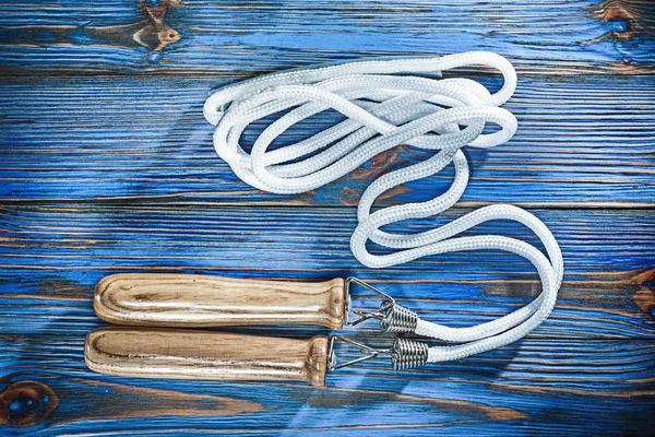 New jumping rope on vintage wooden board.