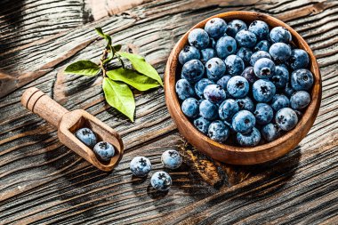 Tahta kaşık kase çiğ huckleberries.