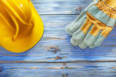 Kask vintage ahşap tahta üzerinde bina koruyucu eldivenler.