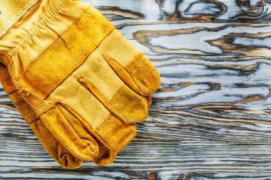 Ahşap tahta üzerinde deri koruyucu eldivenler.