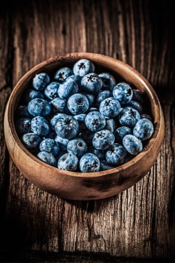 Ahşap kase dikey görünümünde bilberries.