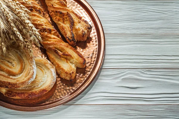 小麦の穂の束焼き菓子真鍮トレイ木製の背景に — ストック写真