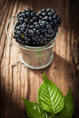 Antika ahşap tahta kova içinde sulu böğürtlen