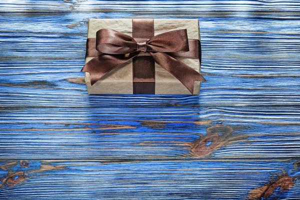 Wrapped brown present box on vintage wooden board — Stock Photo, Image