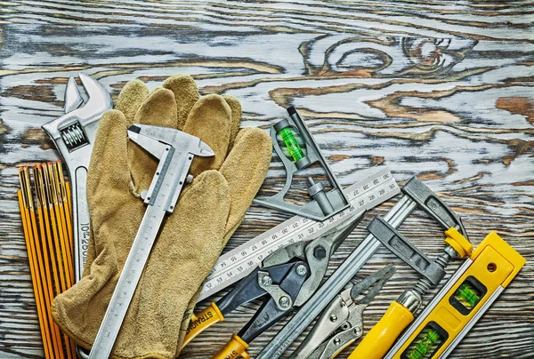 Кожаные защитные перчатки строительные инструменты на деревянной доске — стоковое фото