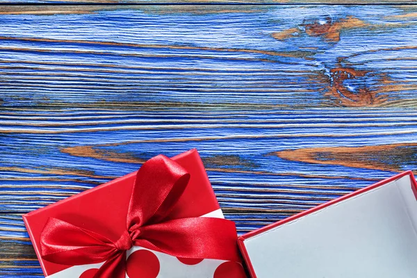 Червона упакована подарункова коробка на старовинній дерев'яній дошці — стокове фото