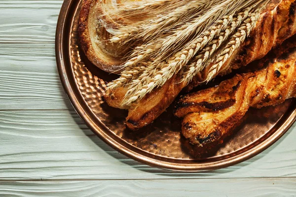 Orejas de trigo bandeja de latón pastelería al horno sobre fondo de madera —  Fotos de Stock