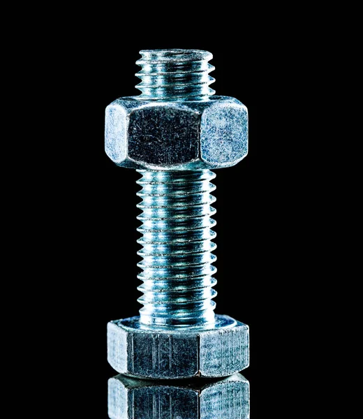 Stainless nut bolt on black surface — Stock Photo, Image