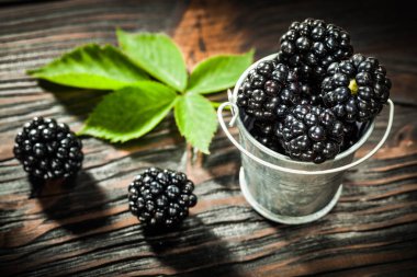 Antika ahşap tahta kova içinde olgunlaşmış dewberries