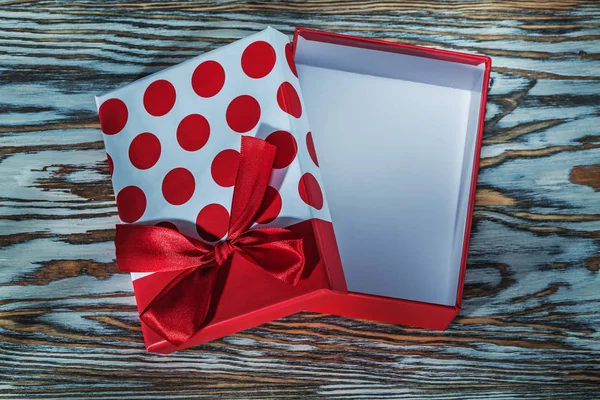 Caja de regalo roja con nudo en tablero de madera vintage —  Fotos de Stock