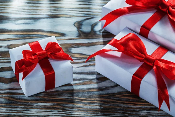 Assortment of red present boxes on wooden surface.