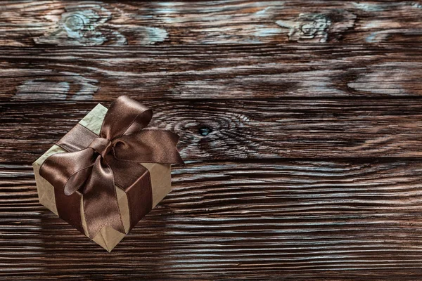 Brown packed gift box on vintage wooden board.
