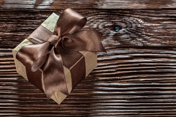 Brown packed present box on vintage wooden board.