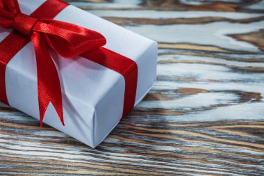 Ahşap arka plan üzerinde kırmızı paketlenmiş hediye kutusu.