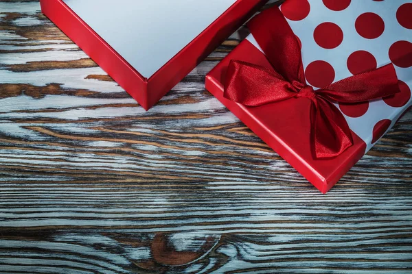 Red present box with bow on vintage wooden board.