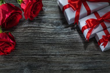 Beyaz hediye kutusu ahşap tahta üzerinde kokulu kırmızı gül demet.