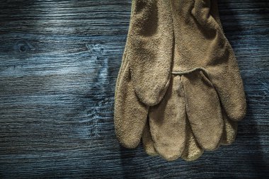 Ahşap tahta üzerinde deri koruyucu eldivenler.