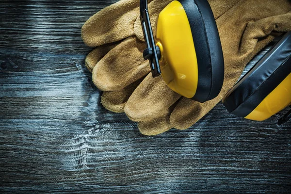 Leder Schutzhandschuhe Ohrenschützer Auf Holzbrett — Stockfoto