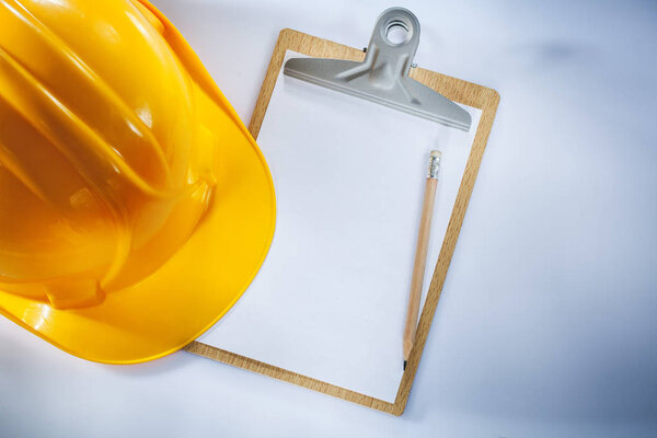 Hard hat clipboard pencil on white background.