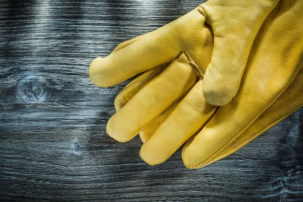Protective gloves on vintage wooden board.