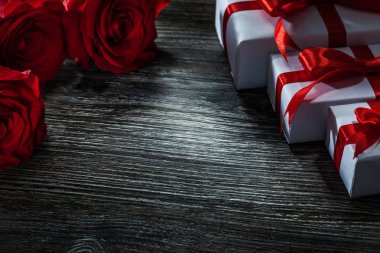 Kırmızı gül beyaz hediye kutuları demet ahşap tahta üzerinde ayarla.