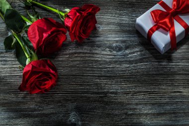 Beyaz Mevcut kutusu demet kırmızı gül ahşap tahta üzerinde.