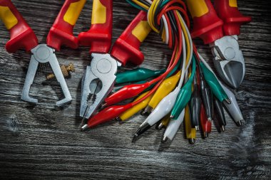 Elektrik telleri pense yalıtım tel kesici kerpeten ahşap tahta üzerinde.