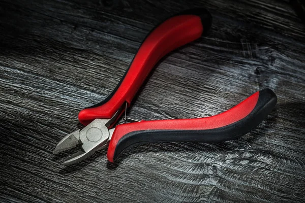 Sharp cutting pliers on wooden board.