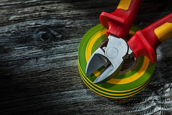 Insulation tape cutting pliers on wooden board.