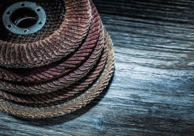 Ahşap tahta üzerinde döner zımpara diskleri yığını.