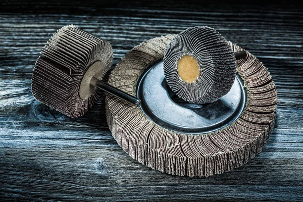 Used rotary flap grinding wheels on vintage wooden board.