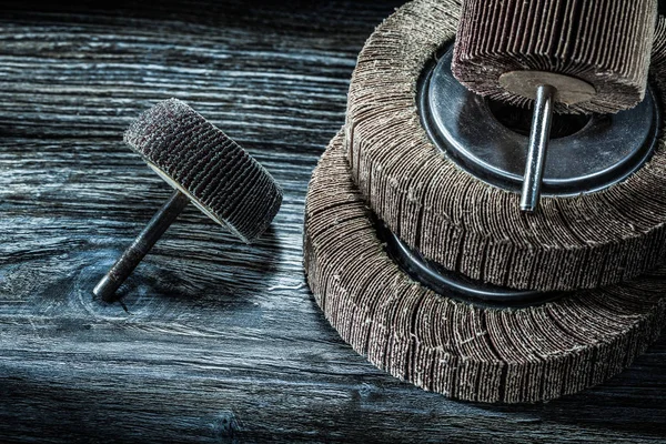 Used rotary abrasive wheels on vintage wooden board top view.