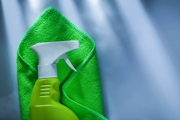 Green washing rag sprayer on white surface.